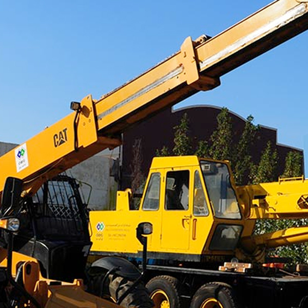 A yellow mobile crane with its boom raised on site