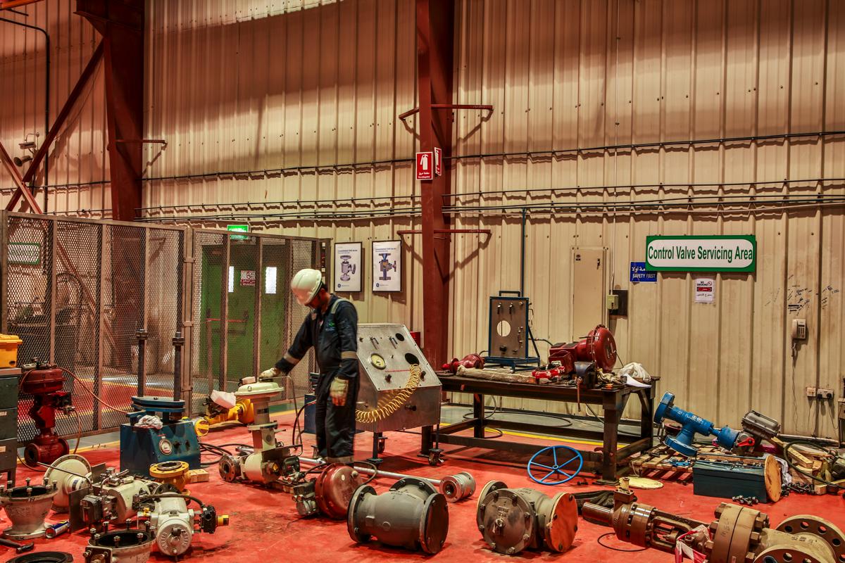 A technician at the test console in the control valve servicing area